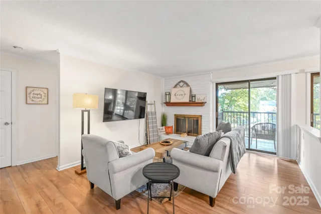 a living room with fireplace furniture and a large window