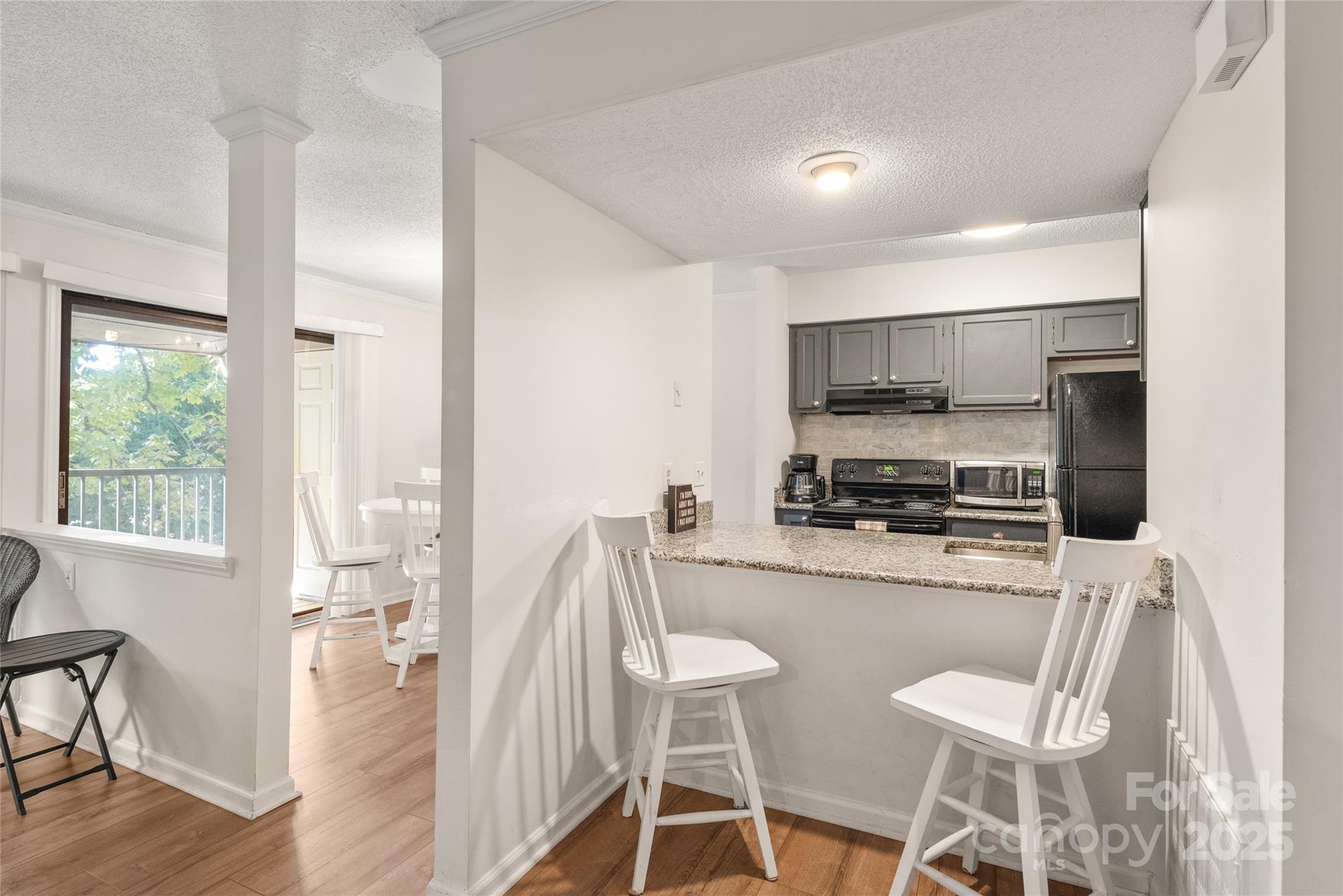 11058 Cedar View Rd. Charlotte, NC 28226 - Photo 11 of 28 a kitchen with stainless steel appliances a dining table chairs refrigerator and microwave