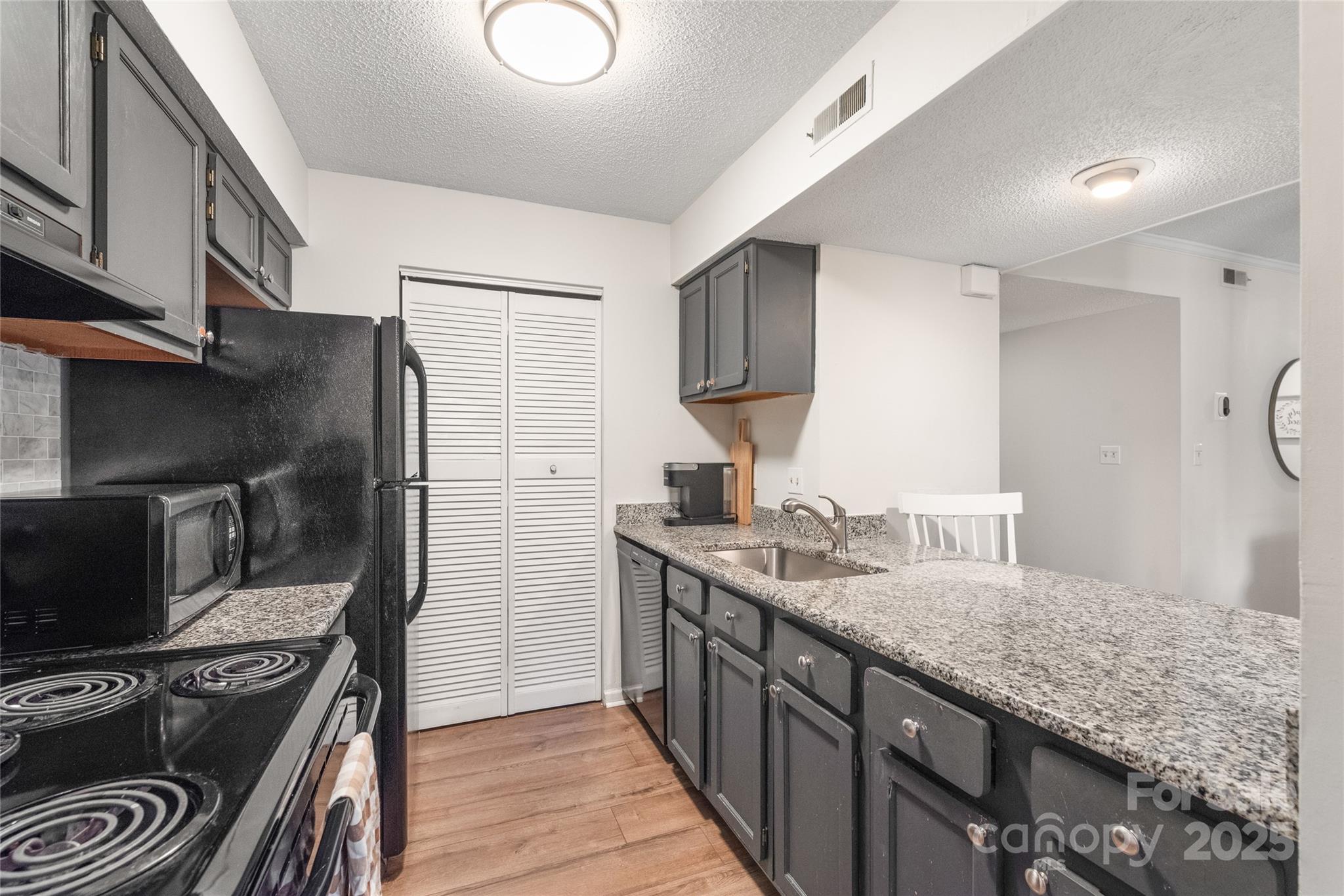 11058 Cedar View Rd. Charlotte, NC 28226 - Photo 14 of 28 a kitchen with stainless steel appliances granite countertop a sink stove and refrigerator