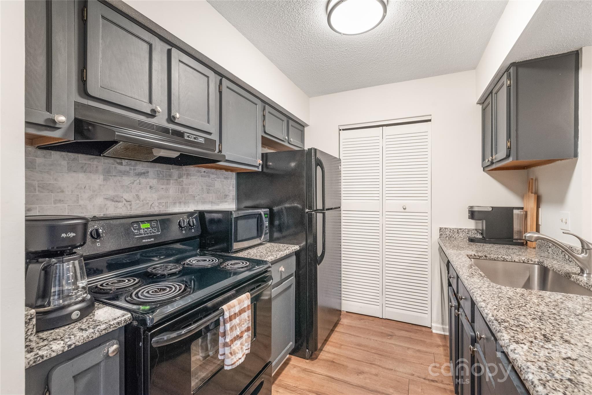 11058 Cedar View Rd. Charlotte, NC 28226 - Photo 15 of 28 a kitchen with stainless steel appliances granite countertop a stove a refrigerator and a sink