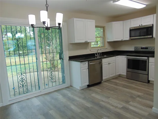 a kitchen with stainless steel appliances granite countertop a stove a sink and a microwave