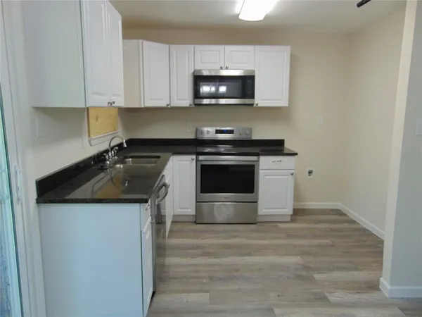 a kitchen with granite countertop a stove and a sink