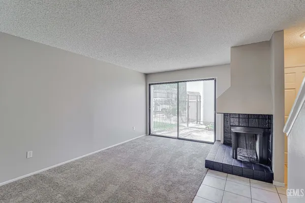 an empty room with fireplace and windows