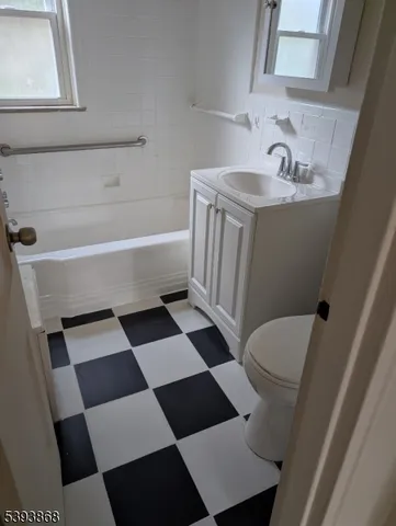 a bathroom with a black white checkered floor and a sink