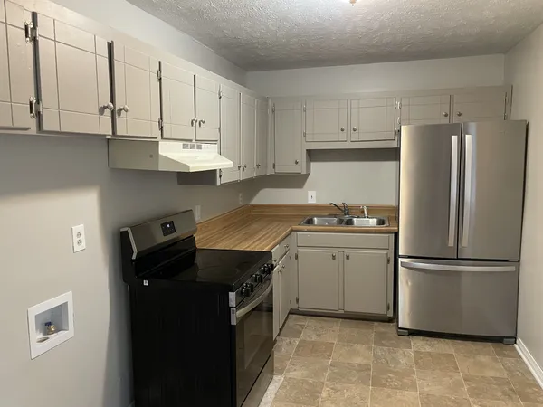 a view of a room with wooden floor and a ceiling fan