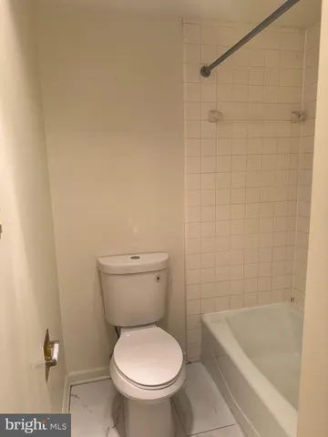 a white toilet sitting next to a bath tub and a shower