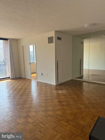 an empty room with wooden floor and windows