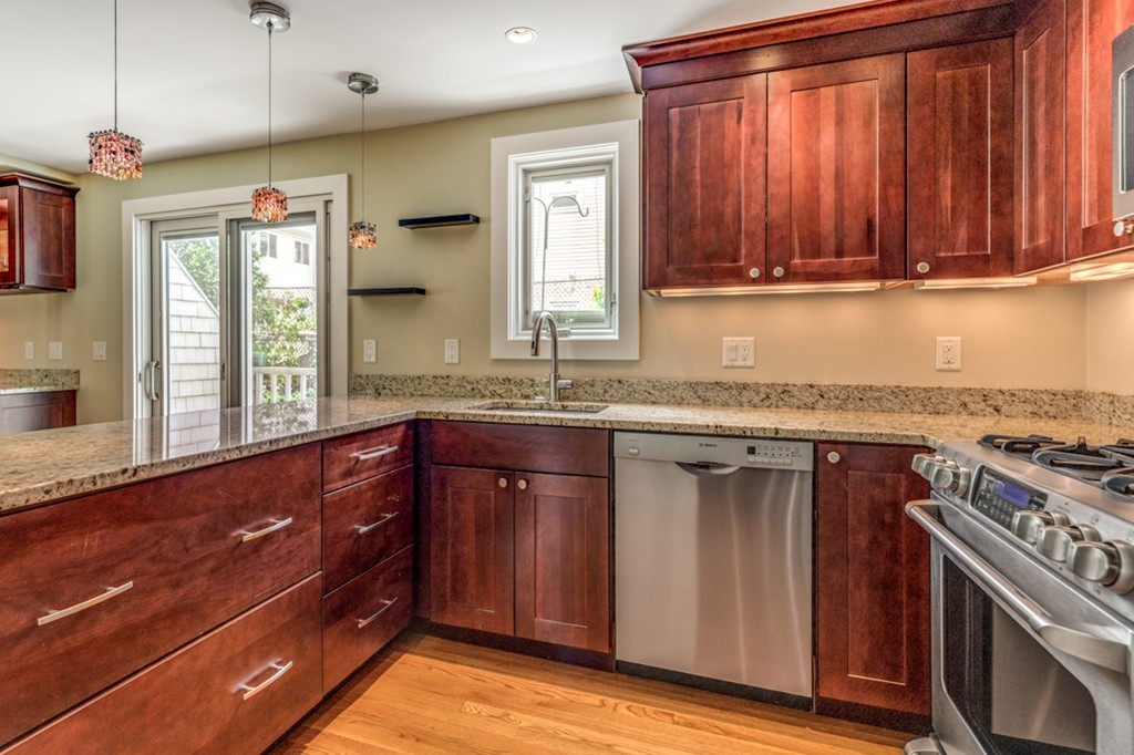 35 Perry Street, Unit 35 Somerville, MA 02143 - Photo 3 of 9 a kitchen with granite countertop cabinets stainless steel appliances a sink and a window
