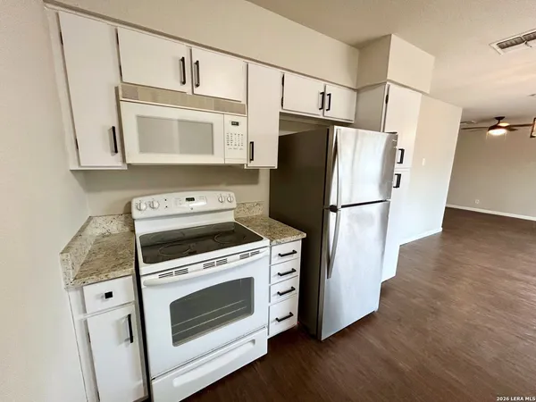 a kitchen with white cabinets and white appliances