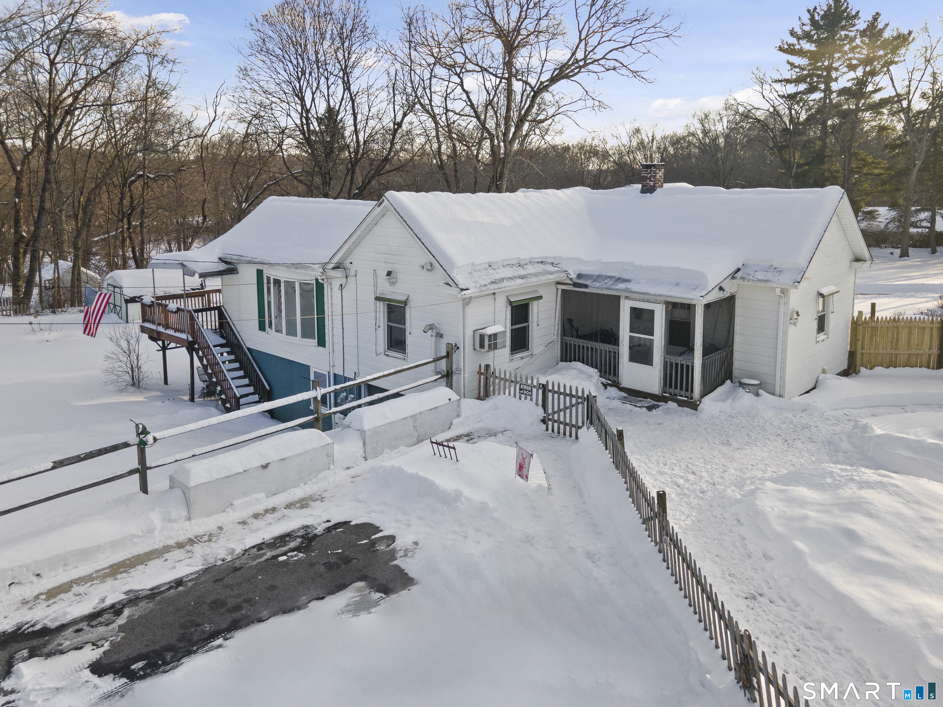 a view of a white house with a big yard and large trees