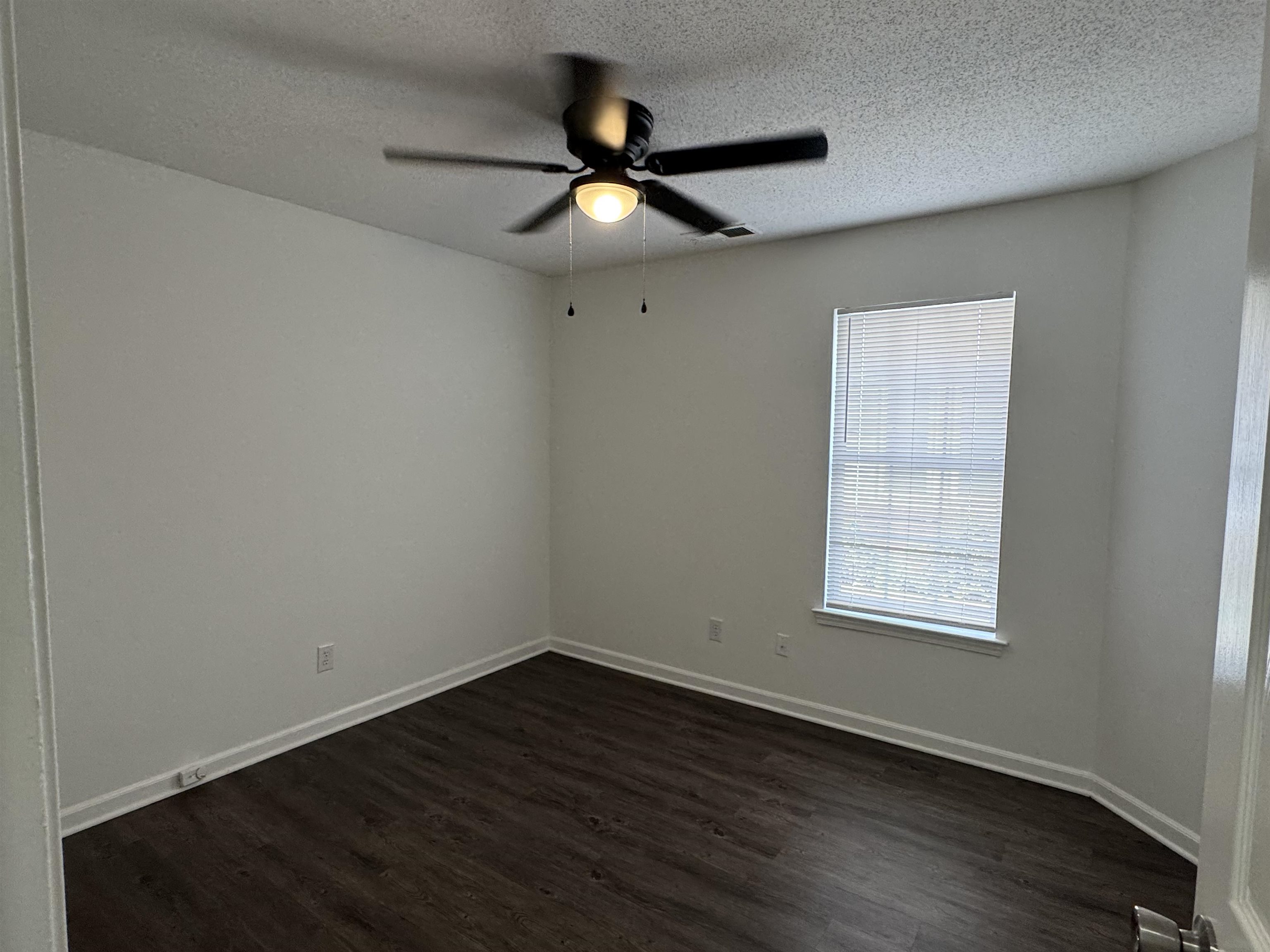6932 Snyder Road Memphis, TN 38141 - Photo 8 of 15 an empty room with wooden floor ceiling fan and windows