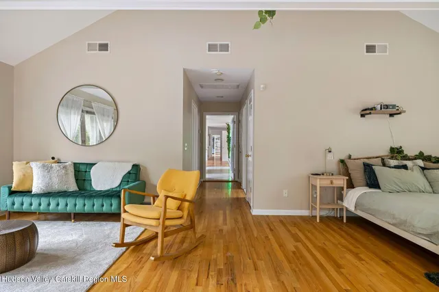 a living room with furniture a flat screen tv and a floor to ceiling window