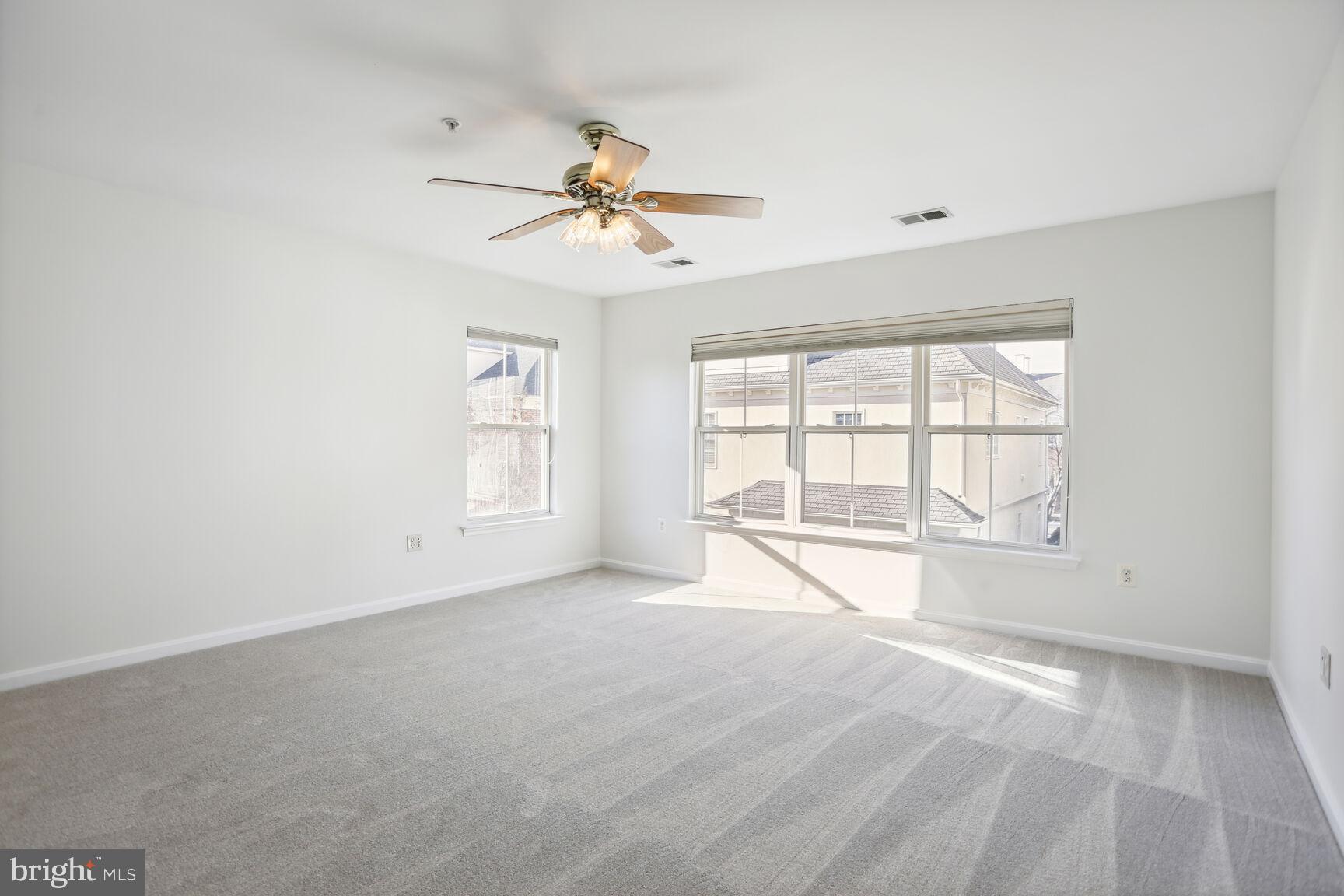 5133 Gardner Drive Alexandria, VA 22304 - Photo 12 of 25 an empty room with chandelier fan and windows