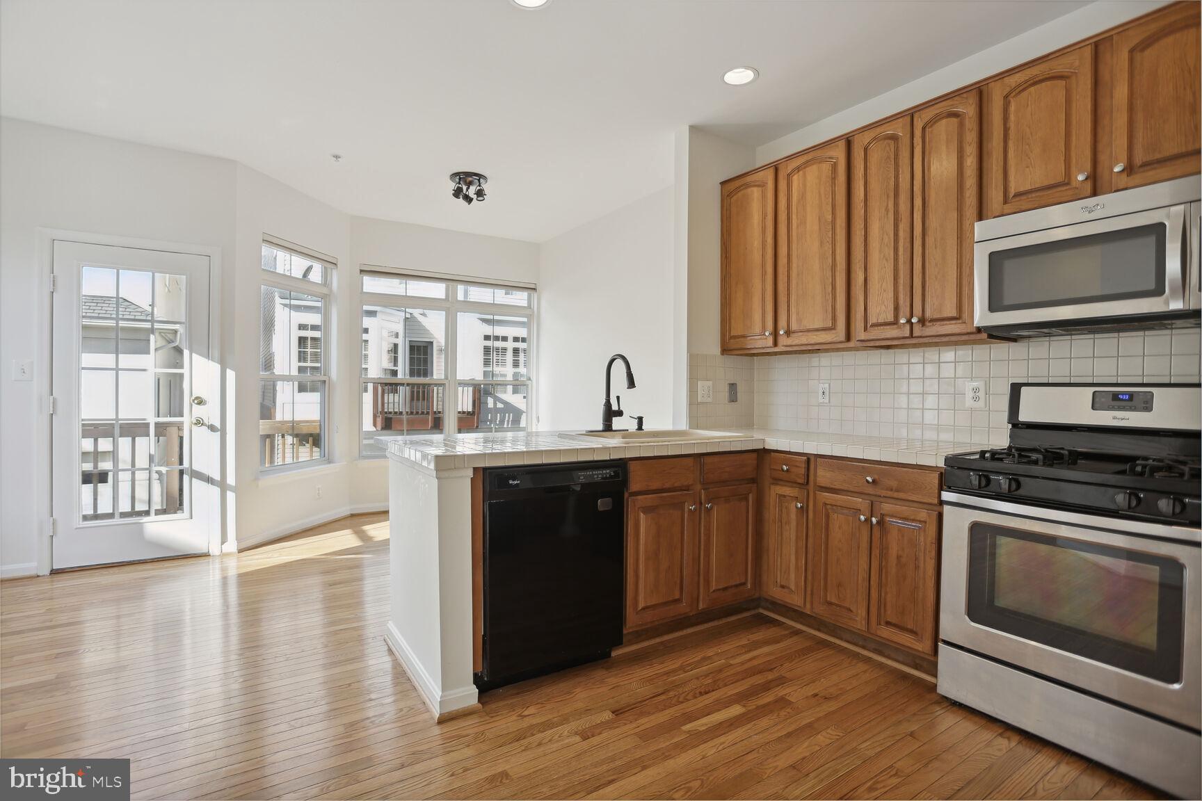 5133 Gardner Drive Alexandria, VA 22304 - Photo 4 of 25 a kitchen with stainless steel appliances granite countertop a stove a sink and a microwave