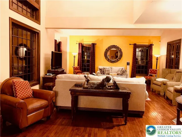 a living room with lots of furniture a rug and a large window