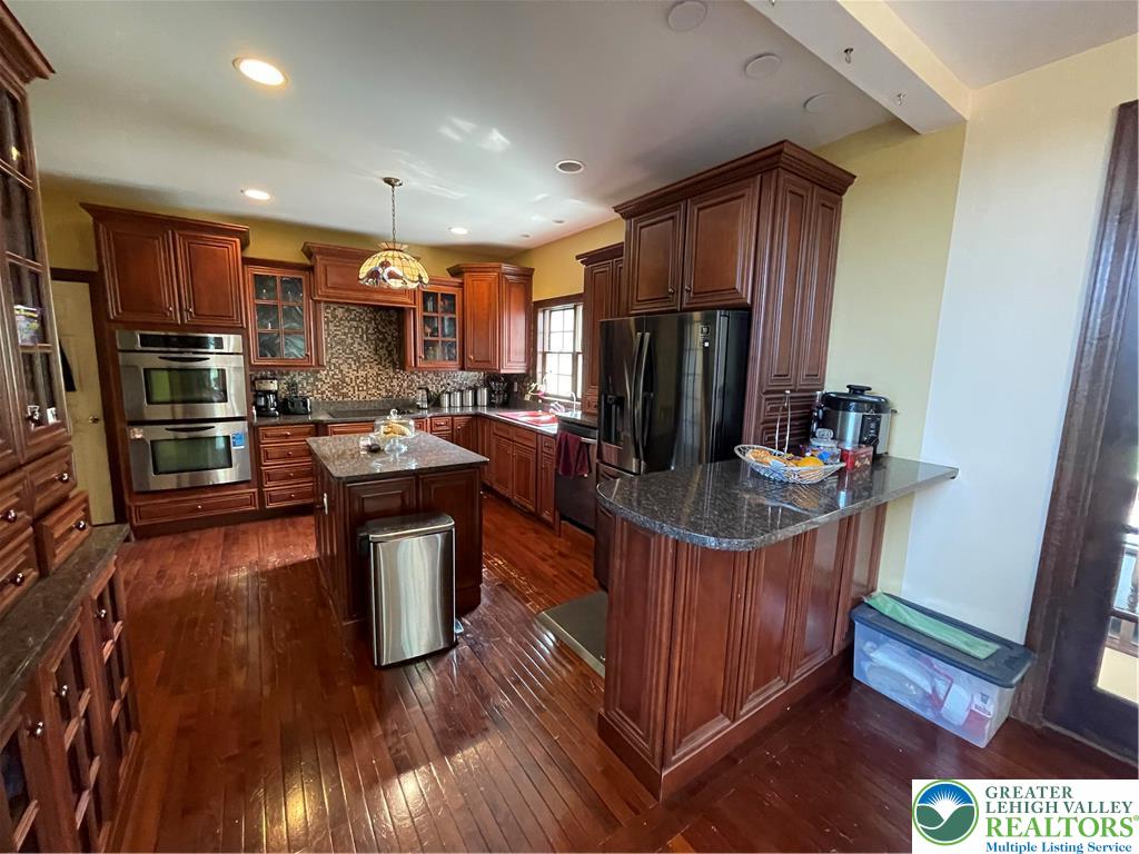 459 Mt Pleasant Road Bangor, PA 18013 - Photo 40 of 86 a kitchen with stainless steel appliances granite countertop a refrigerator a sink dishwasher a stove and a dining table with wooden floor