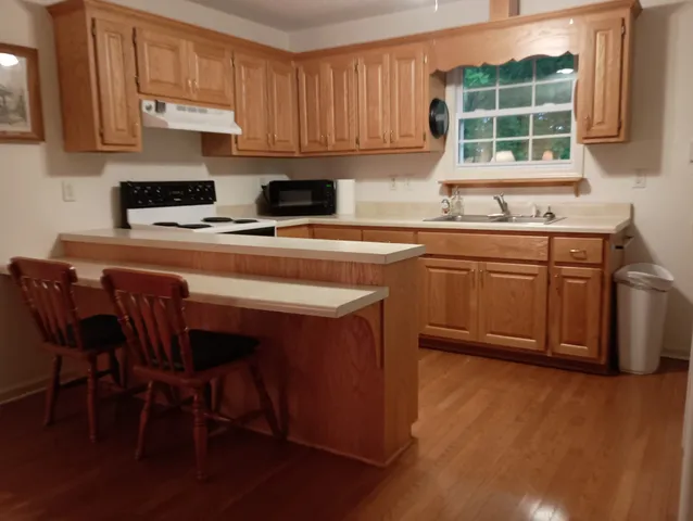 a kitchen with stainless steel appliances granite countertop a stove a sink a microwave refrigerator and cabinets