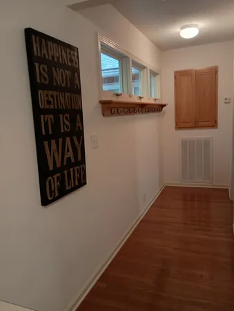 a view of a hallway with wooden floor and closet