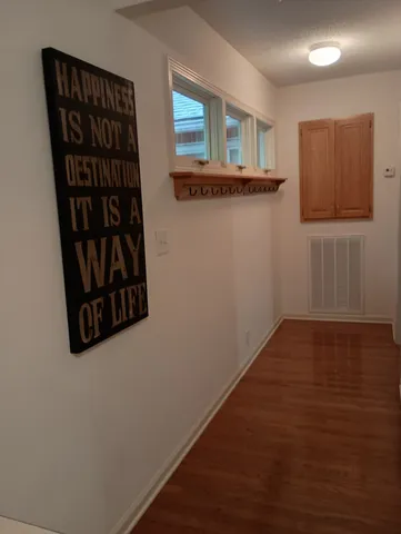 a view of a hallway with wooden floor and closet