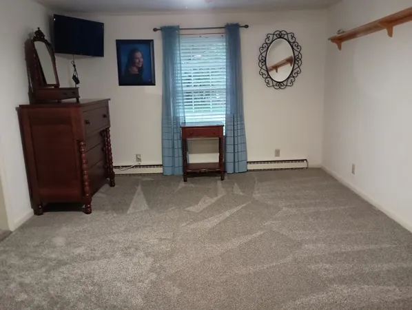 a view of an empty room with a fireplace and a window