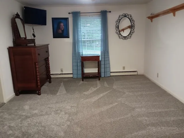 a view of an empty room with a fireplace and a window