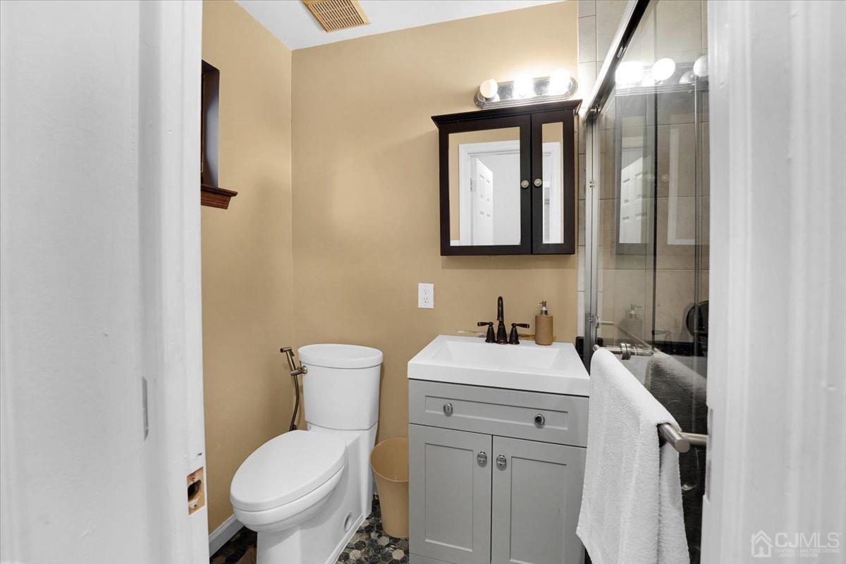 145 Jefferson Boulevard Edison, NJ 08817 - Photo 14 of 35 a bathroom with a toilet sink and mirror