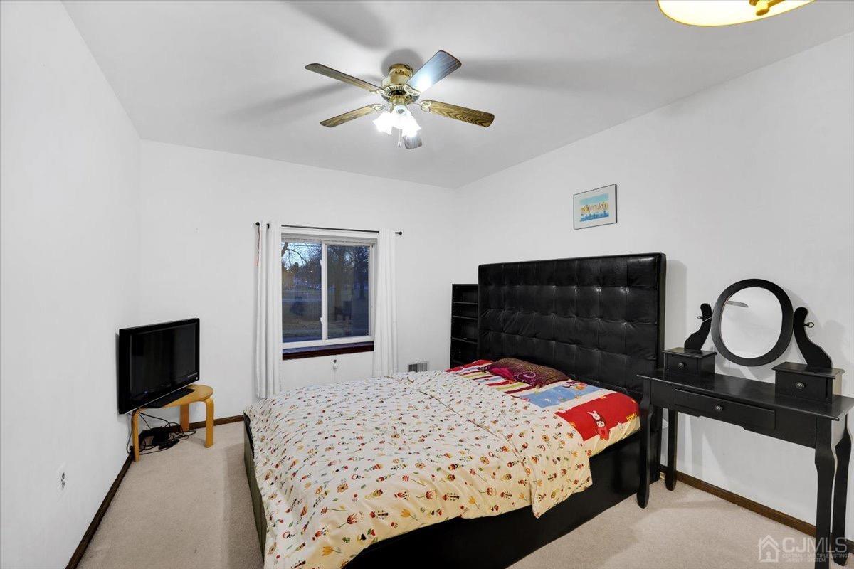 145 Jefferson Boulevard Edison, NJ 08817 - Photo 19 of 35 a bedroom with a bed and a flat tv screen on dresser