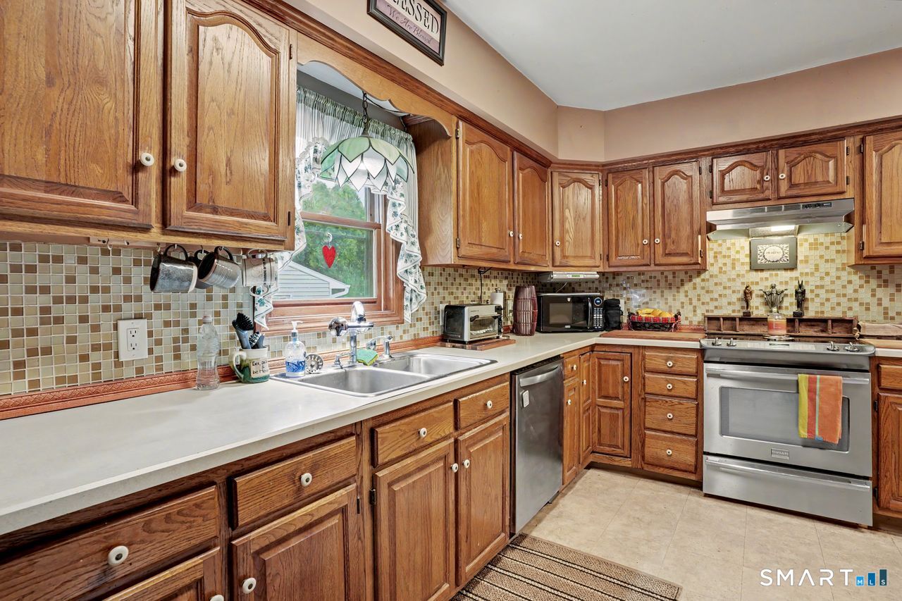 74 Maple Street Seymour, CT 06483 - Photo 8 of 40 a kitchen with stainless steel appliances granite countertop a sink a stove and a microwave