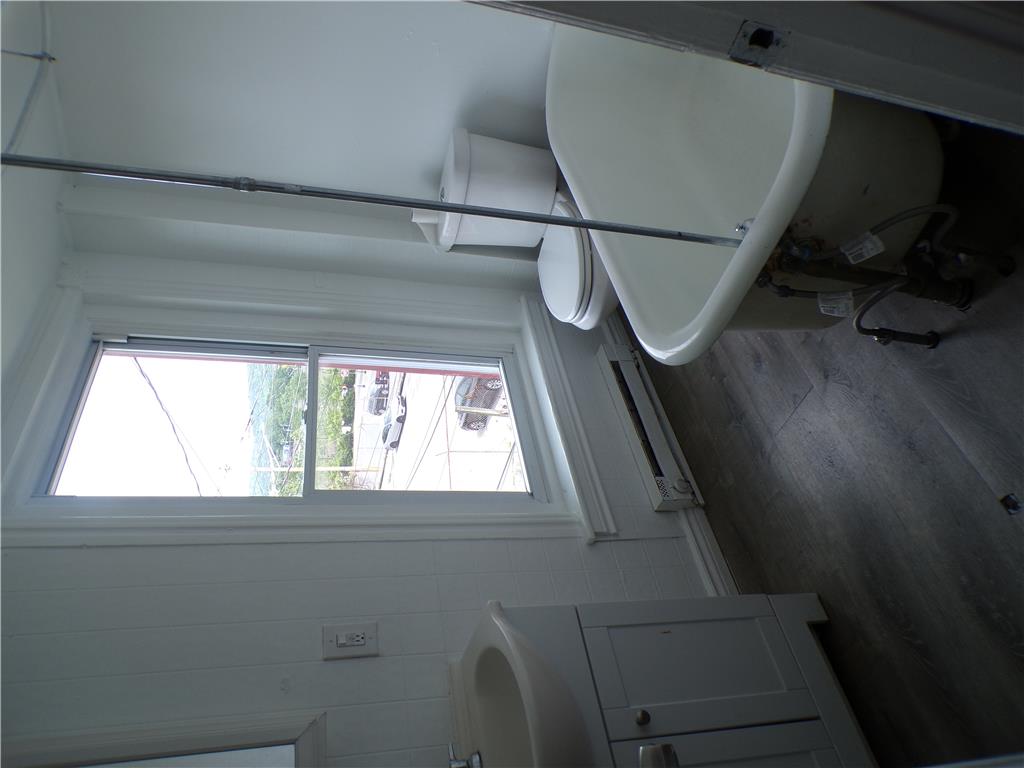 111 Ridge Avenue Allentown, PA 18102 - Photo 10 of 15 A well-lit bathroom features a classic clawfoot tub, wood-look flooring, and window.