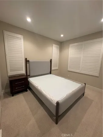a large bed sitting in a room next to a window