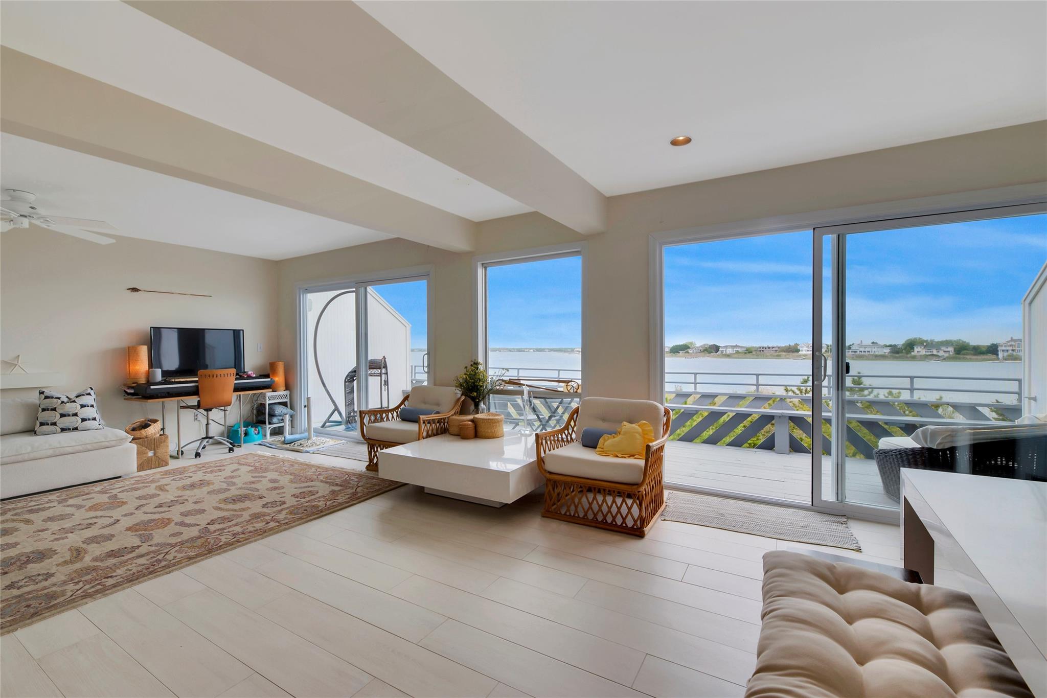 Living room featuring beamed ceiling, ceiling fan, and recessed lighting