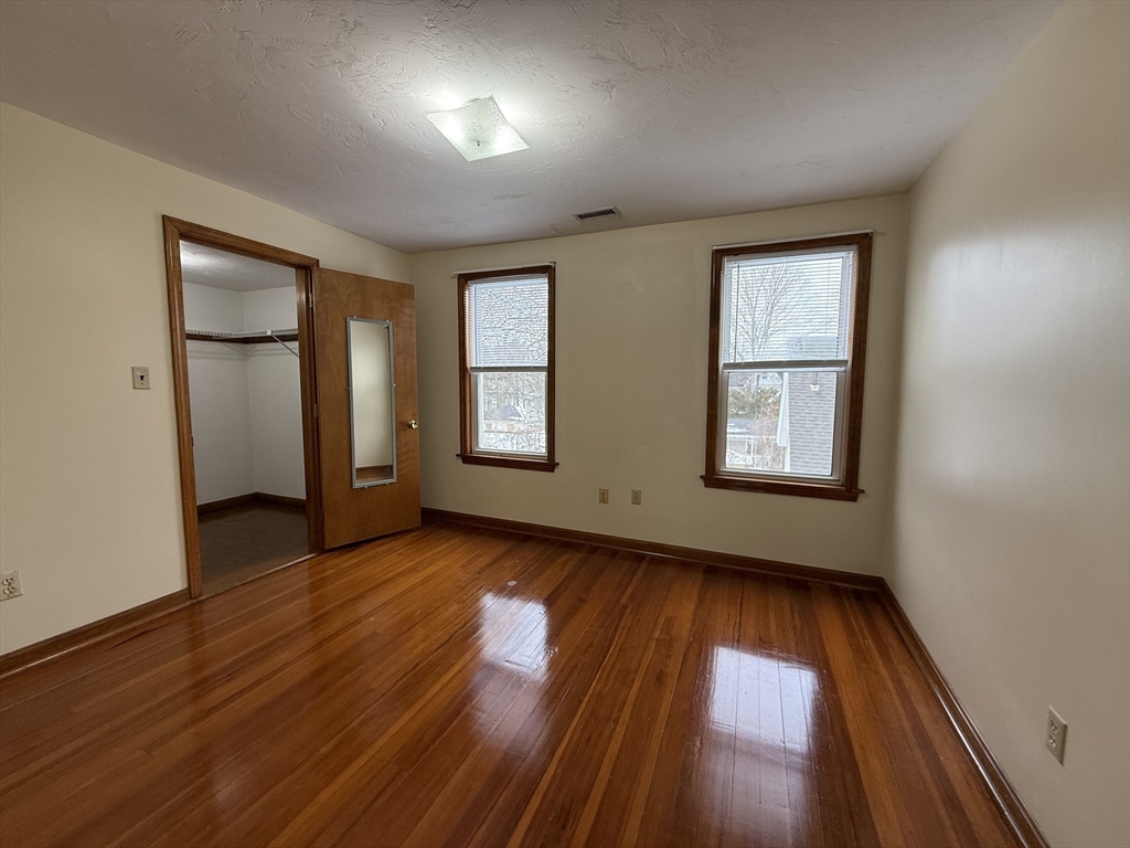 132 Coburn Avenue, Unit 3 Worcester, MA 01604 - Photo 15 of 18 an empty room with wooden floor and windows