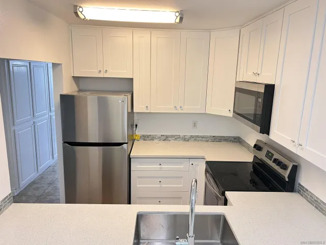 a kitchen with stainless steel appliances a refrigerator a stove a microwave and cabinets