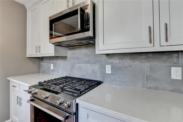 a kitchen with granite countertop a stove and a microwave