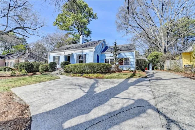 a house with yard and trees in front of it