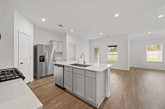 a kitchen with stainless steel appliances granite countertop a refrigerator and a stove top oven