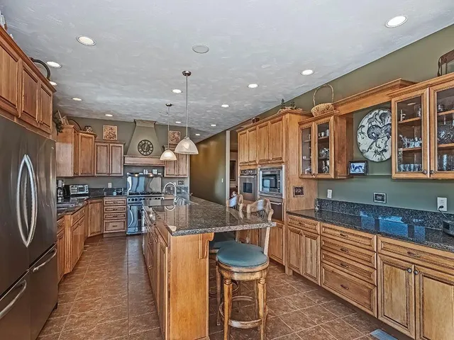 a kitchen with stainless steel appliances kitchen island granite countertop a sink and cabinets