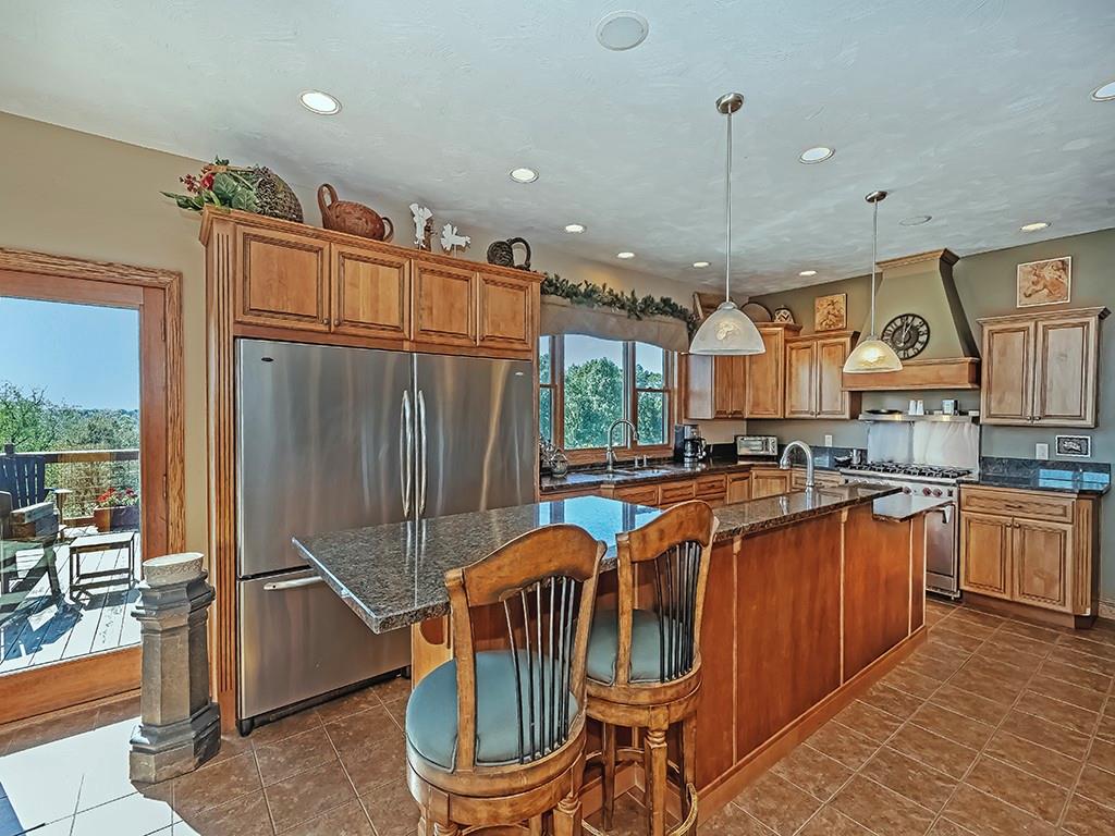 166 McKay Road Saxonburg, PA 16056 - Photo 14 of 47 a kitchen with stainless steel appliances granite countertop a refrigerator a stove a sink dishwasher a dining table and chairs with wooden floor