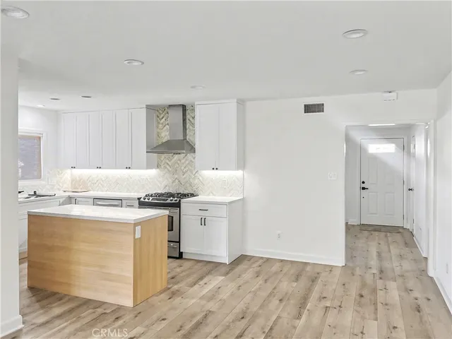 a kitchen with stainless steel appliances granite countertop a stove and a white cabinets