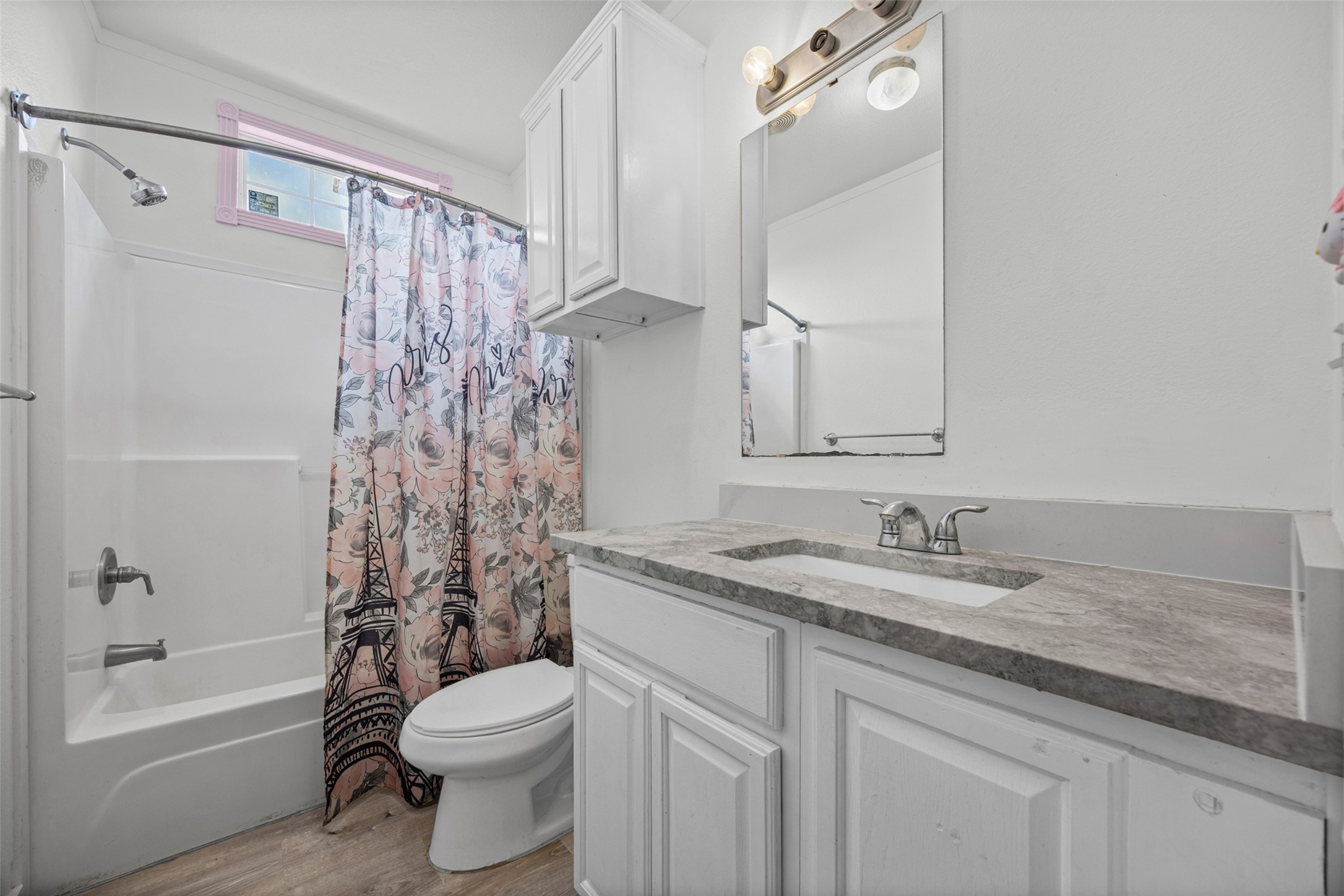 120 Mimosa Road Dale, TX 78616 - Photo 14 of 21 A well-appointed bathroom features a single vanity, a standard tub and shower combination, and wood-look flooring.