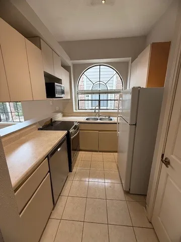 a kitchen with stainless steel appliances granite countertop a refrigerator sink and cabinets