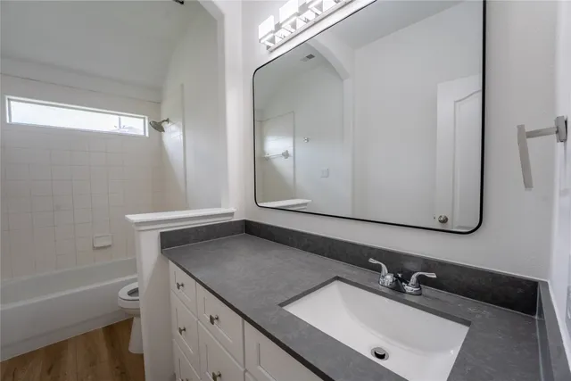 a bathroom with a sink vanity granite tub and a mirror