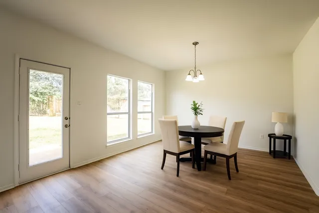 a dining room with furniture window and wooden floor