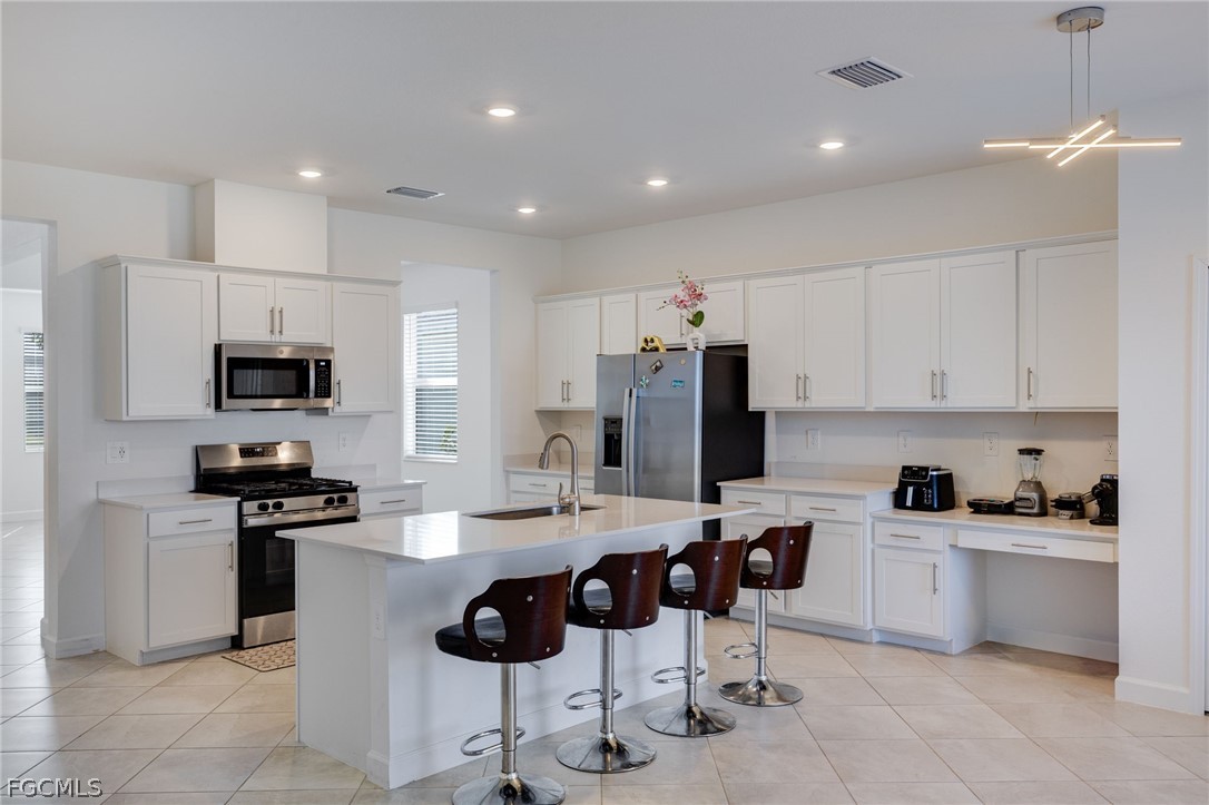 14961 Anchorage Road Punta Gorda, FL 33982 - Photo 10 of 32 a kitchen with stainless steel appliances a stove a sink a microwave a refrigerator and cabinets