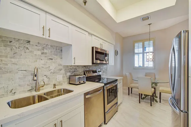 a kitchen with stainless steel appliances a sink a stove and a refrigerator