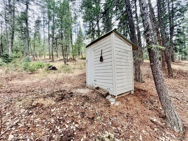 a view of a house with a yard and large trees