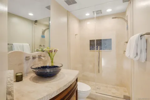 a bathroom with a granite countertop sink a toilet and shower
