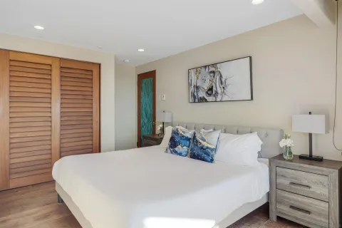 a large bed sitting in a bedroom next to a window