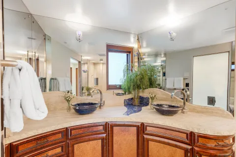a kitchen with a sink dishwasher and white cabinets with wooden floor