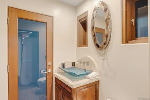 a bathroom with a granite countertop sink and a mirror